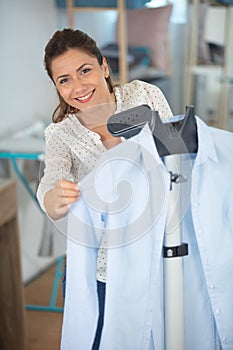 woman steaming blue shirt in room