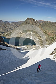 Woman On Steep Snowfield In The Mountains photo