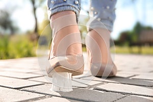 Woman stepping in chewing gum on sidewalk