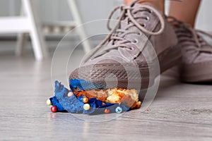 Woman stepping on dropped cupcake indoors, closeup. Troubles happen