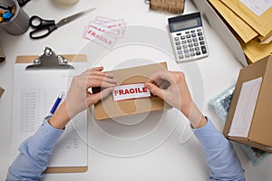 Woman sticking fragile mark to parcel box