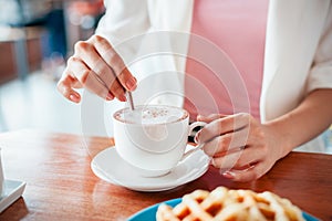 Woman stirring coffee