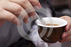 Woman Stirring a Coffee with a Spoon