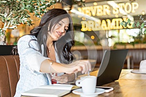 Woman stirring a coffee while working sitting in the coffee shop