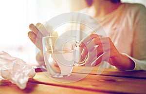 Woman stirring medication in cup with spoon