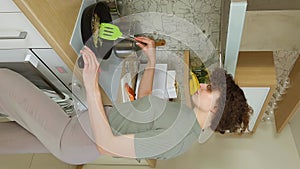 Woman stirring vegetables in a frying pan