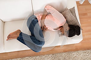 Woman With Stomach Ache Lying On Sofa photo