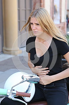 Woman with stomachache on a scooter photo