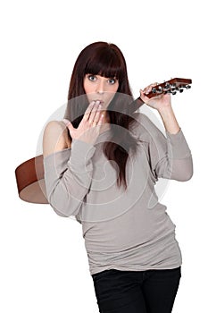 Woman stood holding acoustic guitar
