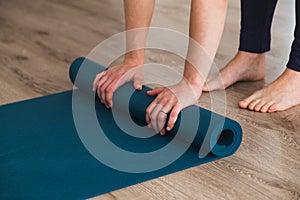 Woman unrolling her yoga mat in a studio photo