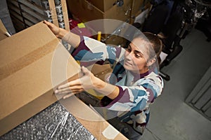 Woman Storing Boxes in Storage Unit