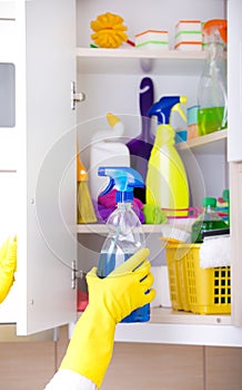 Woman storing cleaning tools in pantry photo