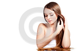 Woman straightens brown hair on white background