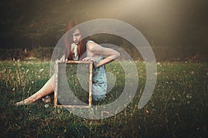 Woman with strange mirror on a meadow