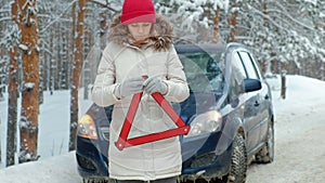 Woman with a straw car on the road in winter