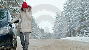 Woman with a straw car on the road in winter