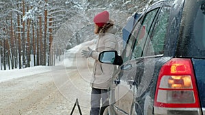 Woman with a straw car on the road in winter