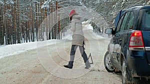 Woman with a straw car on the road in winter