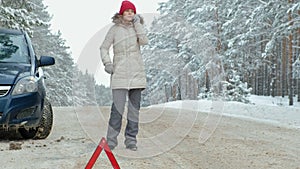 Woman with a straw car on the road in winter