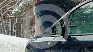 Woman with a straw car on the road in winter