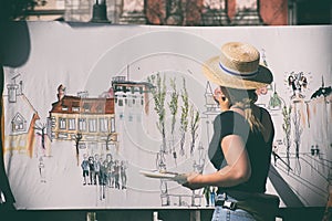 Woman street artist at work painting
