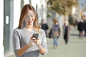 Una mujer en calles que pasa través elegante teléfono 