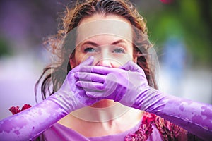 Woman on the street covering her mouth with her hands