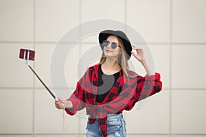 A woman in the street is smiling. Selfy. beige background