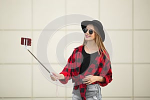 A woman in the street is smiling. Selfy. Blue background