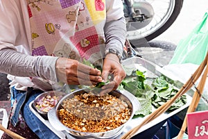 Woman street vendor making Miang Kam