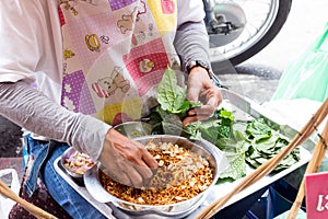 Woman street vendor making Miang Kam
