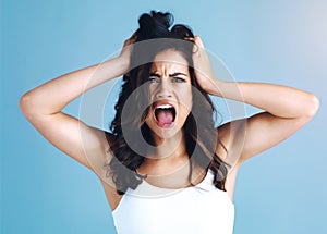 Woman, stress and hair care in studio portrait with mess, shouting and cosmetics by blue background. Girl, shock and wow