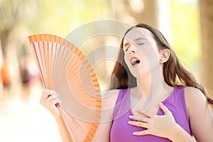 Woman stressing fanning on summer in a park photo