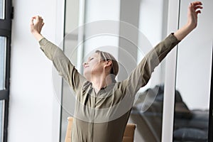 Woman stretches arms and back after monotonous work at table