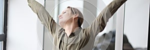 Woman stretches arms and back after monotonous work at table