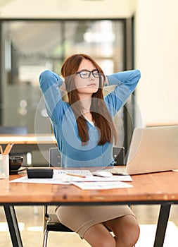 Woman stretches her arms when tired in the office, business woman relaxes, office syndrome