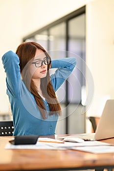 Woman stretches her arms when tired in the office, business woman relaxes, office syndrome