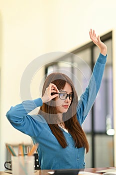 Woman stretches her arms when tired in the office, business woman relaxes, office syndrome