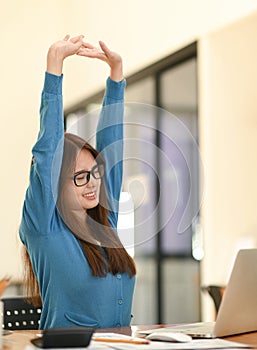 Woman stretches her arms when tired in the office, business woman relaxes, office syndrome