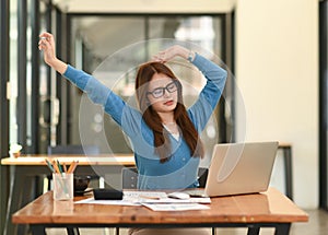 Woman stretches her arms when tired in the office, business woman relaxes, office syndrome