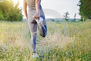 Woman stretches legs before jogging
