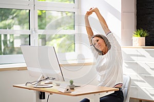 Woman Stretches At Office Desk