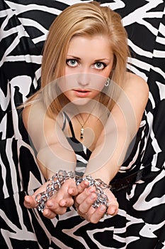 woman stretches out her hands in chains