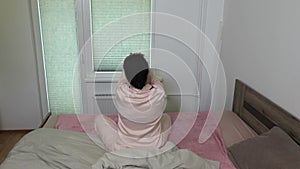 Woman stretches out near window in the morning