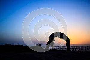 Woman stretches yoga sunset silhouette