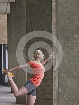 Woman Stretching Against Pillar In Portico