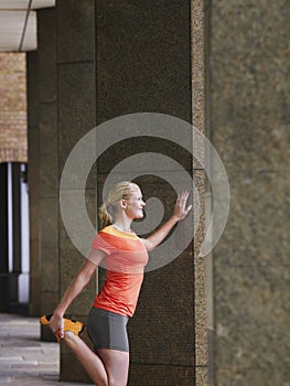 Woman Stretching Against Pillar In Portico