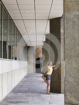Woman Stretching Against Pillar In Portico