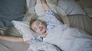 Woman stretching arms in bed