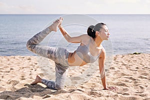 woman stretching on the beach with yoga poses